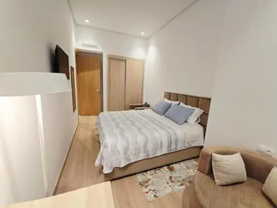 a bedroom with a bed and a couch at Studio Élégant avec piscine à Zenata Eco city in Aïn Harrouda