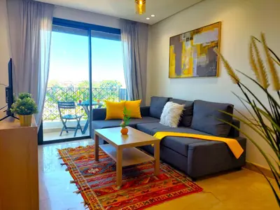 a living room with a blue couch and a table at Welcome Home Palmiers in Casablanca