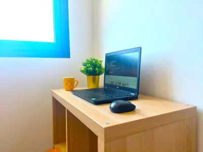 a laptop computer sitting on a wooden desk with a mouse at Welcome Home Palmiers in Casablanca