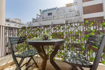 a table and chairs on a balcony with a fence at Welcome Home Palmiers in Casablanca