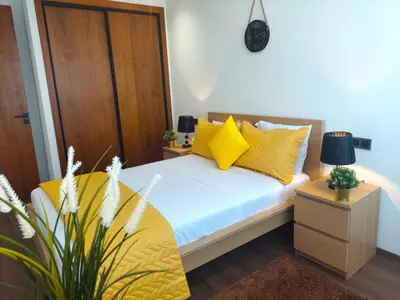a bedroom with a bed with yellow pillows at Welcome Home Palmiers in Casablanca