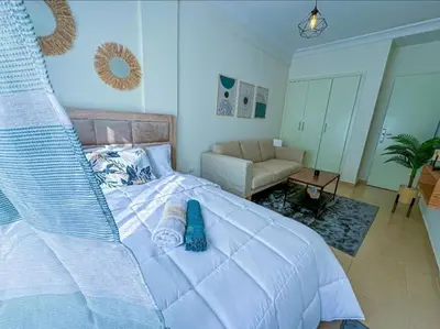 a bedroom with a large white bed and a couch at très joli appartement vue sur mer présentation acte de mariage si couple in Rabat