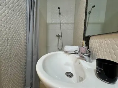 a bathroom with a white sink and a mirror at très joli appartement vue sur mer présentation acte de mariage si couple in Rabat