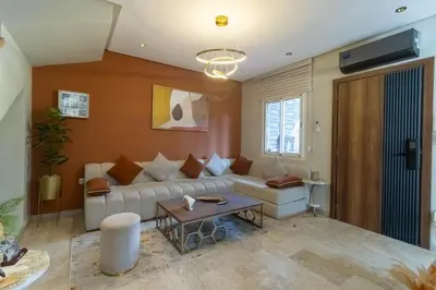a living room with a couch and a table at L Évasion ZEN Duplex d Exception Entre Plage et Serenite in Mohammedia