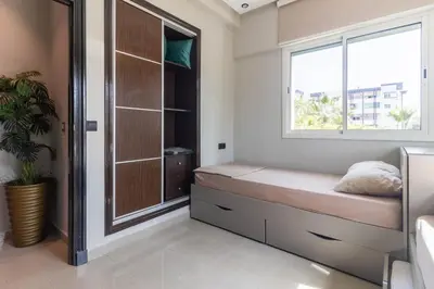 a small bedroom with a window and a bed at L Évasion ZEN Duplex d Exception Entre Plage et Serenite in Mohammedia