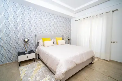 a bedroom with a bed with yellow pillows at Welcome to Casa Luxe 3 King Beds Near CFC & Tram in Casablanca