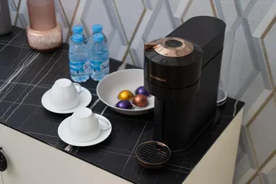 a black coffee maker on a counter with plates and fruit at Welcome to Casa Luxe 3 King Beds Near CFC & Tram in Casablanca