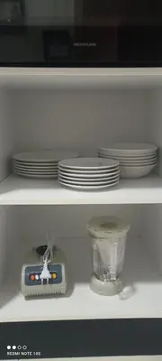 a microwave sitting on top of a shelf with dishes at Cosy Appartement piscine view Magic house Mansouria in Mansouria