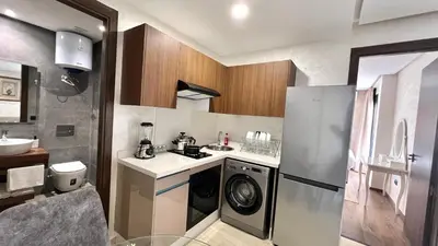 a small kitchen with a washer and dryer in it at Appartement chic à Bourgogne Proche mosquèe Hassan II in Casablanca