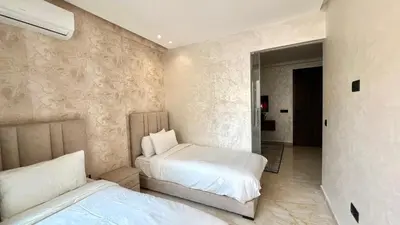 a bedroom with two beds and a mirror at Appartement chic à Bourgogne Proche mosquèe Hassan II in Casablanca