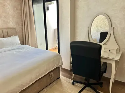 a bedroom with a bed and a desk and a chair at Appartement chic à Bourgogne Proche mosquèe Hassan II in Casablanca
