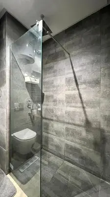 a bathroom with a glass shower with a toilet at Appartement chic à Bourgogne Proche mosquèe Hassan II in Casablanca