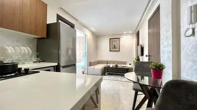 a kitchen and a living room with a table at Appartement chic à Bourgogne Proche mosquèe Hassan II in Casablanca
