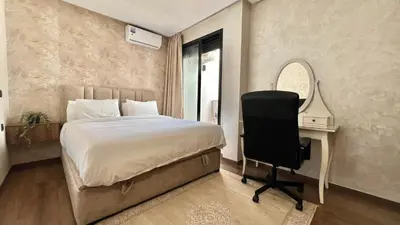 a bedroom with a bed and a desk and a chair at Appartement chic à Bourgogne Proche mosquèe Hassan II in Casablanca
