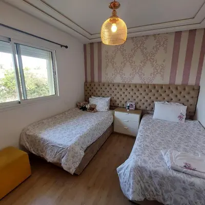 a bedroom with two beds and a window at Havre de paix à TAMARIS in Dar Mohammed Ould Haj Jilali
