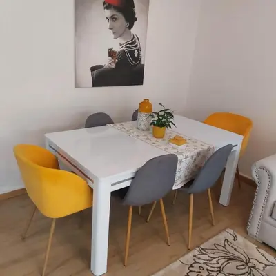 a white dining room table with chairs and a painting at Havre de paix à TAMARIS in Dar Mohammed Ould Haj Jilali