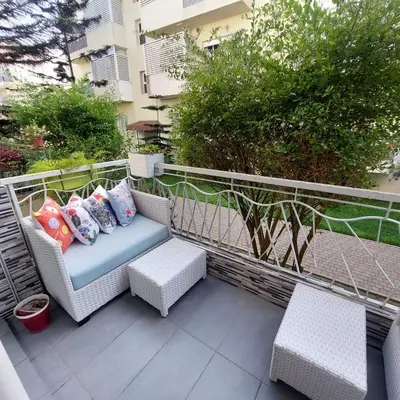a patio with a couch and two chairs on a balcony at Havre de paix à TAMARIS in Dar Mohammed Ould Haj Jilali