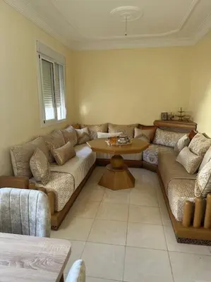a living room with a couch and a table at Well-equipped luxury apartment in Temara
