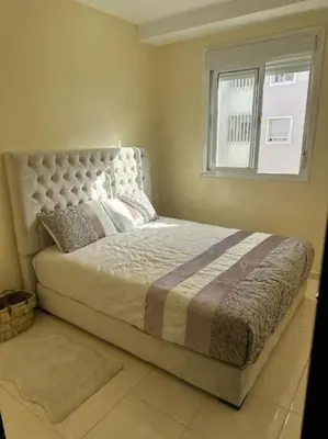 a bedroom with a large bed with a window at Well-equipped luxury apartment in Temara