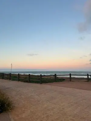 a fence next to the beach at sunset at Dar Bouazza getaway in Tamaris