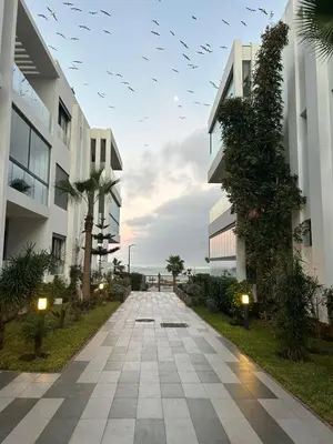 a walkway between two buildings with birds flying overhead at Dar Bouazza getaway in Tamaris