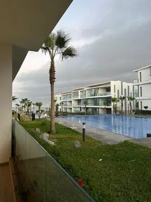 a palm tree in front of a building with a pool at Dar Bouazza getaway in Tamaris