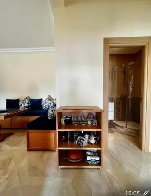a room with a couch and a shelf with shoes at Appartement de vacances CASABAY Sidi Rehal in Sidi Rahal