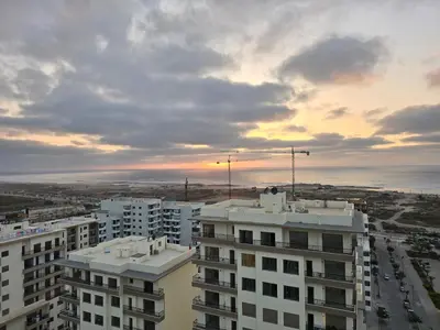 a view of a building with the ocean in the background at Duplex Zenata Tower in Aïn Harrouda