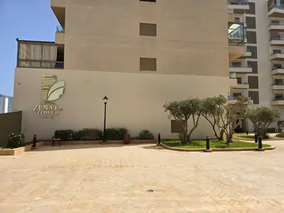 a building with a sign on the side of it at Duplex Zenata Tower in Aïn Harrouda