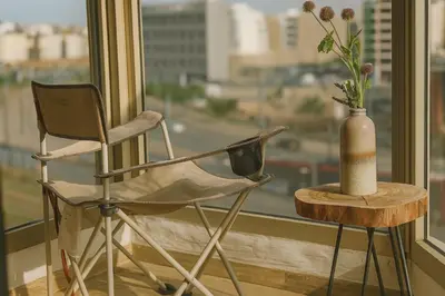 a chair and a vase on a table next to a window at Cosy and sunny - private Rooftop - near train & tramway in Casablanca