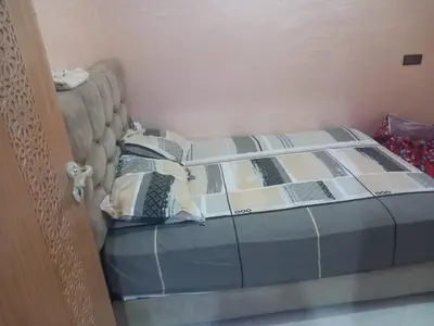 a bed in a room with a bed frame at appartement bouznika in Bouznika
