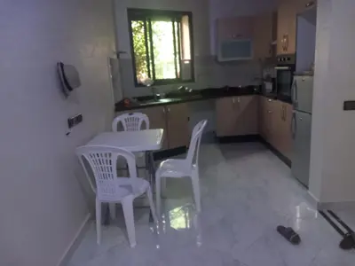 a kitchen with a table and two chairs and a table at appartement bouznika in Bouznika