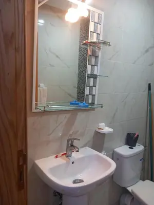 a bathroom with a sink and a mirror and a toilet at appartement bouznika in Bouznika