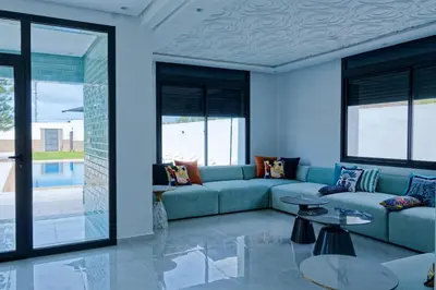 a living room with a couch and a table at Villa Luxe Dar Bouazza - Piscine Privée - Fibre 100Mb - 3 min Plage in Casablanca