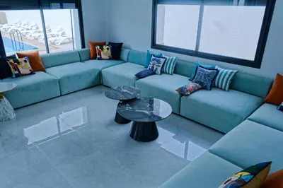 a living room with a blue couch and a table at Villa Luxe Dar Bouazza - Piscine Privée - Fibre 100Mb - 3 min Plage in Casablanca