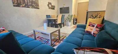 a living room with a blue couch and a table at Quiet and Cozy Apartment in Casablanca