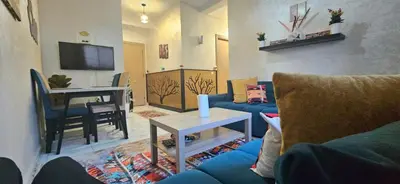 a living room with a blue couch and a table at Quiet and Cozy Apartment in Casablanca