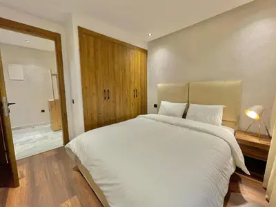 a bedroom with a large white bed and a bathroom at Q11 Studio au Cœur de Casablanca Proximité et Confort in Casablanca