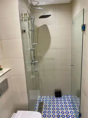 a bathroom with a glass shower with a toilet at Zafiro - L'appartement de vos rêves - Casablanca in Casablanca