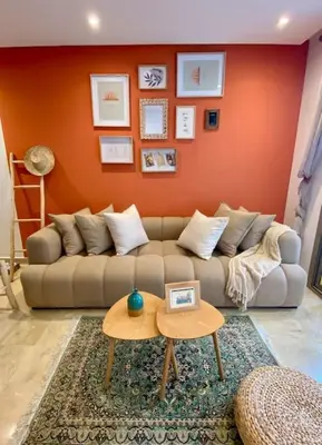a living room with a couch and an orange wall at Zafiro - L'appartement de vos rêves - Casablanca in Casablanca