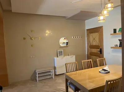 a dining room with a table and a refrigerator at Family Appartement Nouaceur Aéroport Med V in Nouaceur