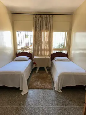 two beds in a room with two windows at Chambre cosy au cœur de Rabat in Rabat
