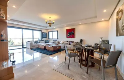 a living room with a table and a couch at Appartment De Lux a California in Bali Luxury Residence in Casablanca