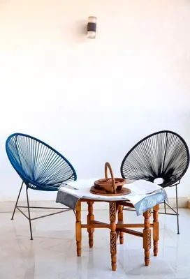 two chairs and a table with a blue chair at Appartment De Lux a California in Bali Luxury Residence in Casablanca