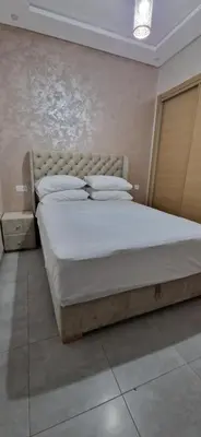 a bedroom with a large bed with white sheets and pillows at Cozy Guesthouse, Ain Sebaa, Casablanca in Casablanca