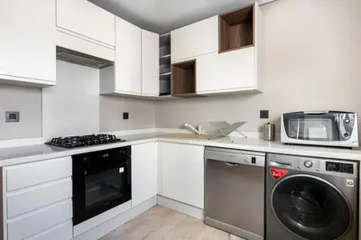 a white kitchen with a dishwasher and a microwave at TT holidays Casa Oasis in Casablanca