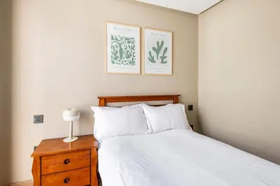 a bedroom with a white bed and a wooden nightstand at TT holidays Casa Oasis in Casablanca