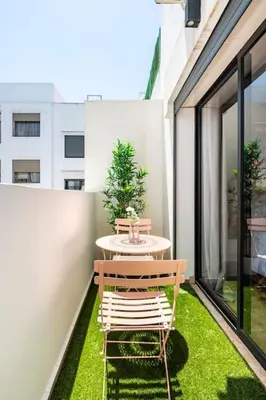 a table and chairs on a balcony with grass at TT holidays Casa Oasis in Casablanca