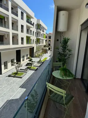 a balcony with chairs and tables on a building at Résidence Natura Living au parc in Mohammedia