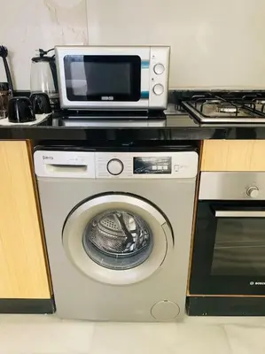 a microwave and a washing machine in a kitchen at Studio cosy in Nouaceur